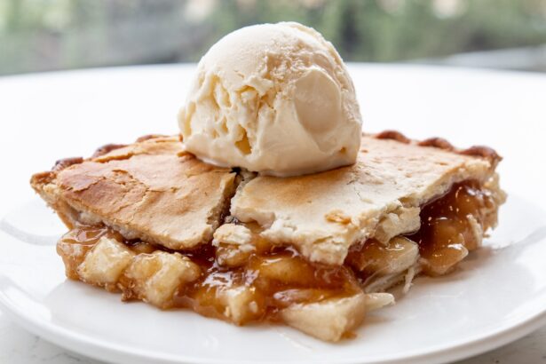 A slice of apple pie with a scoop of vanilla ice cream on a plate.